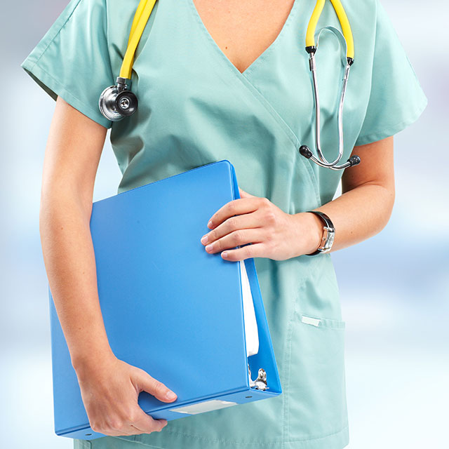 Female nurse standing from neck down with blue binder