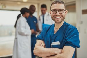 Male nurse standing in front of blurred group of people